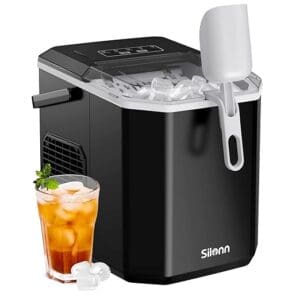 A black and silver ice maker next to an orange drink.