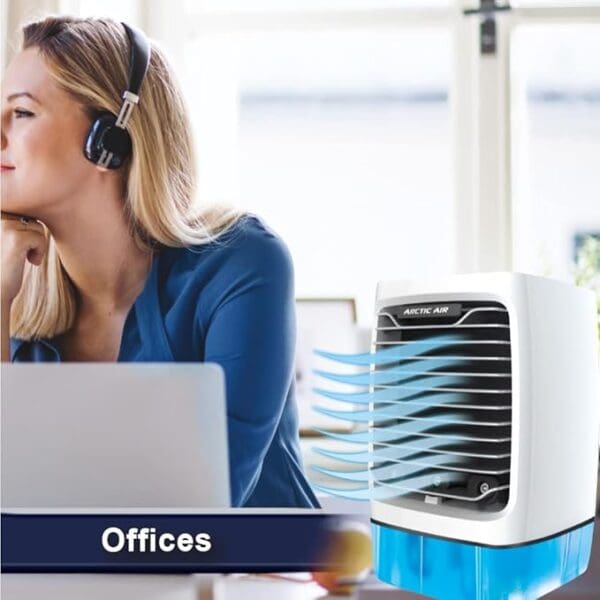 A woman sitting at her desk with an air conditioner.