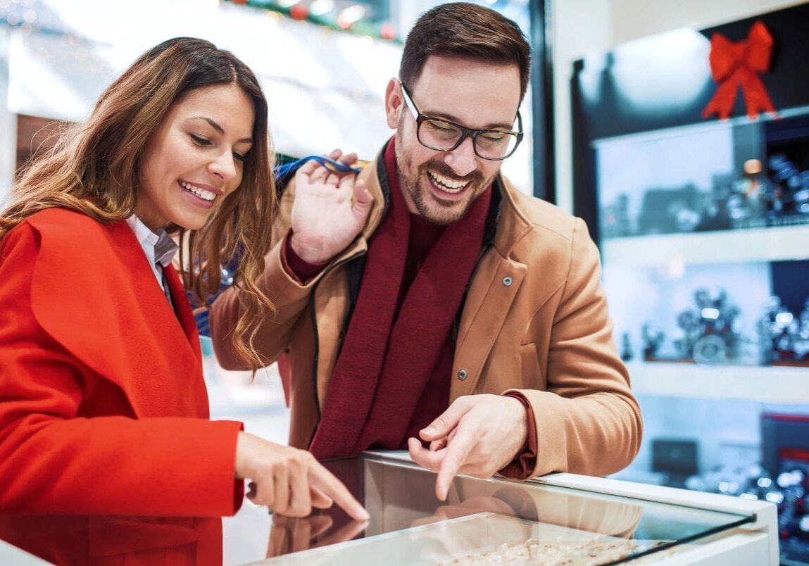 Shopping time. Young couple looking at jewels in jewelry shop. Consumerism, love, dating, lifestyle concept